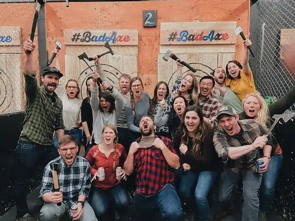 A group posed at Bad Axe Throwing, a great team outing in Denver, CO