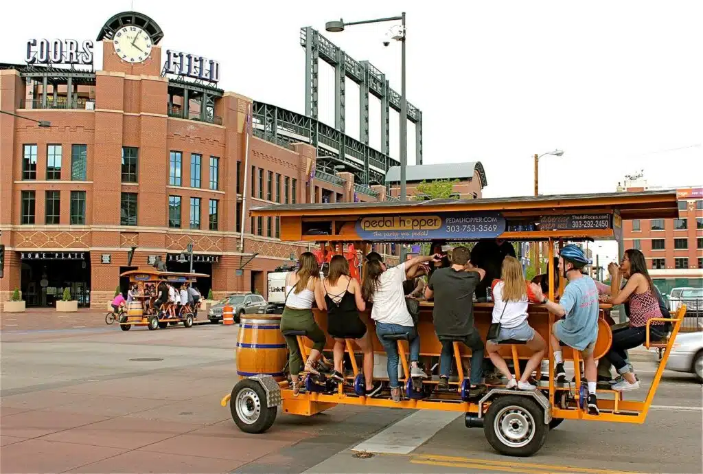 Two Pedal Hopper mobile pubs crossing paths outside Coors Field