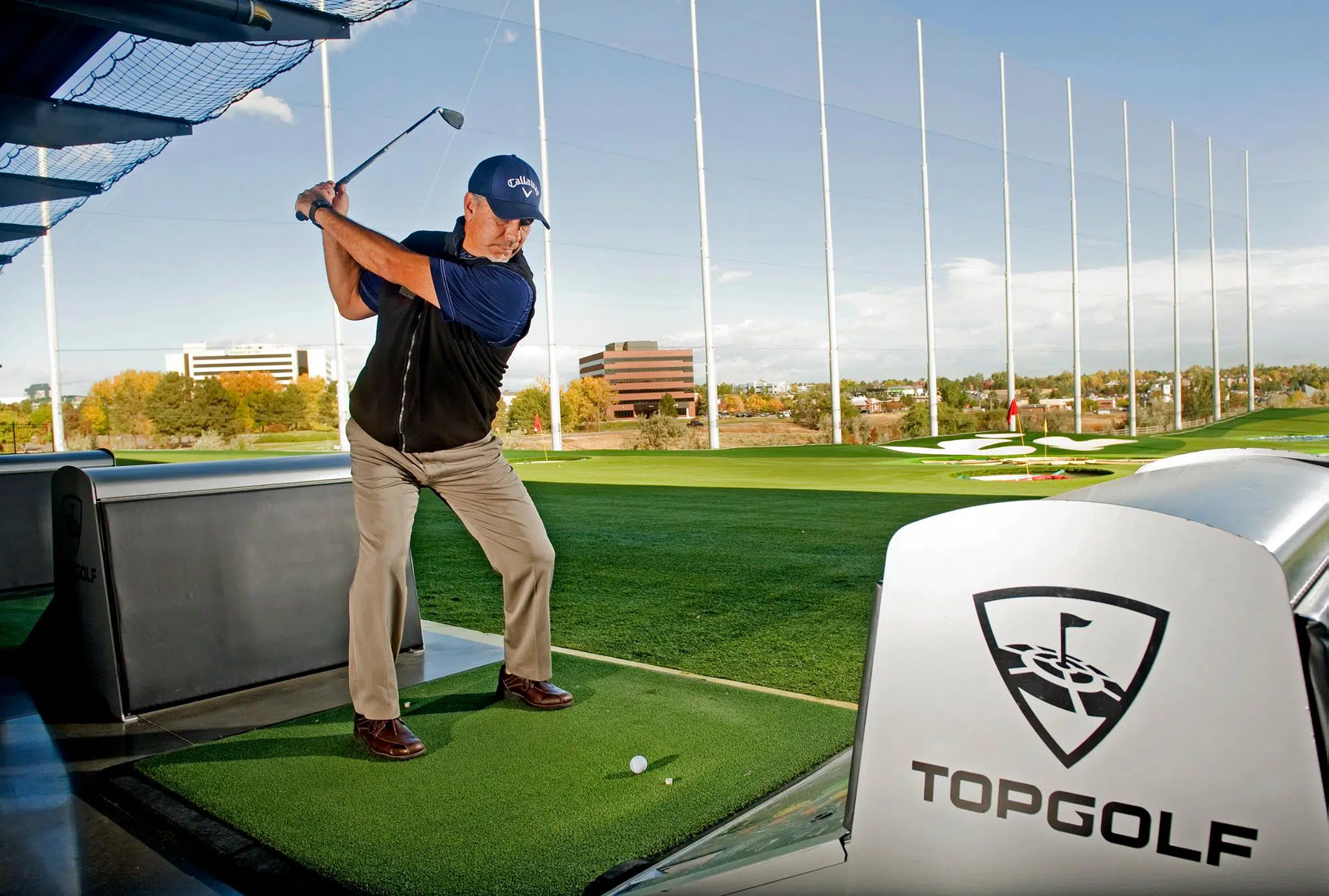 A man taking a swing at Topgolf