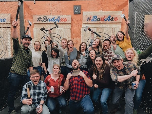 A group posed at Bad Axe Throwing, a great team outing in Denver, CO