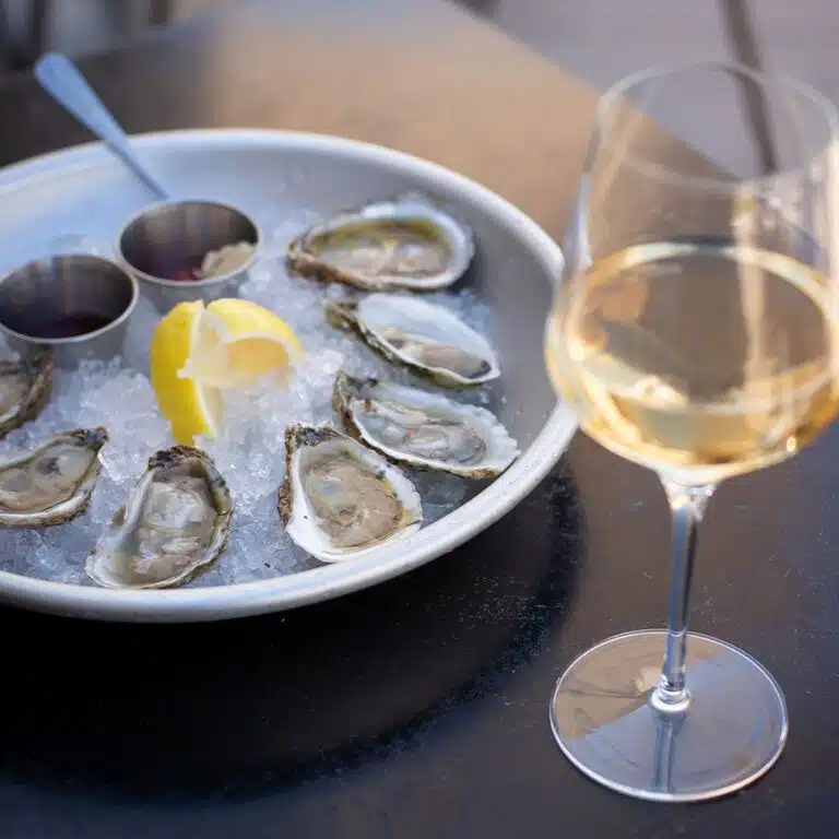 Chilled oysters and a glass of white wine at Angelo's Taverna, which offers one of the best Denver happy hours for wine drinkers