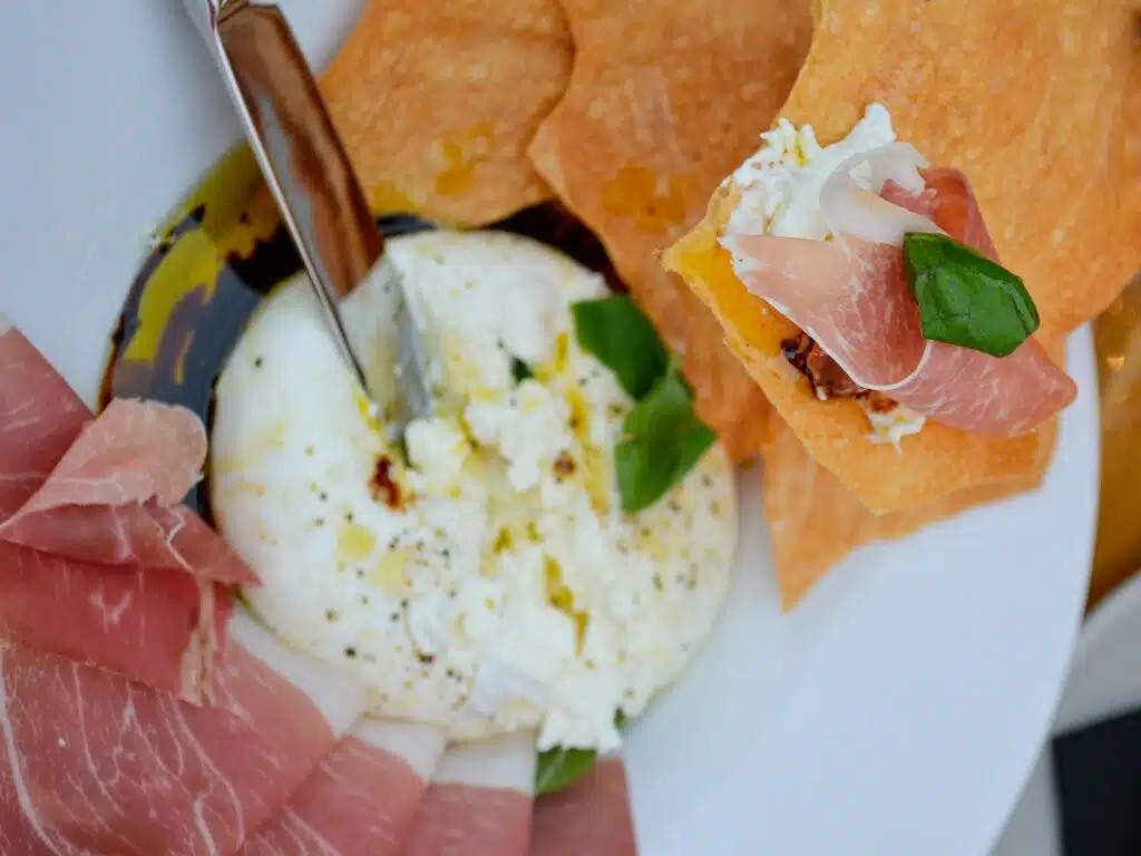 Housemade burrata, prosciutto, and baked crackers from Il Posto