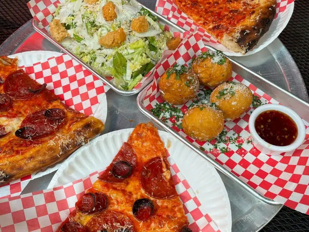 Caesar salad, garlic knots, and pepperoni slices from Redeemer Pizza