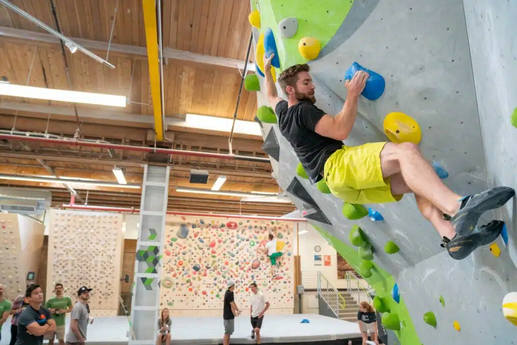 A man bouldering at Movement, a climbing gym collective with a location in RiNo