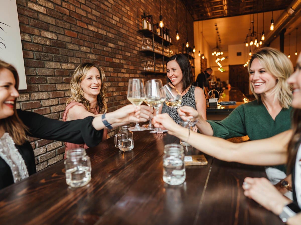 A group of women clinking wine glasses