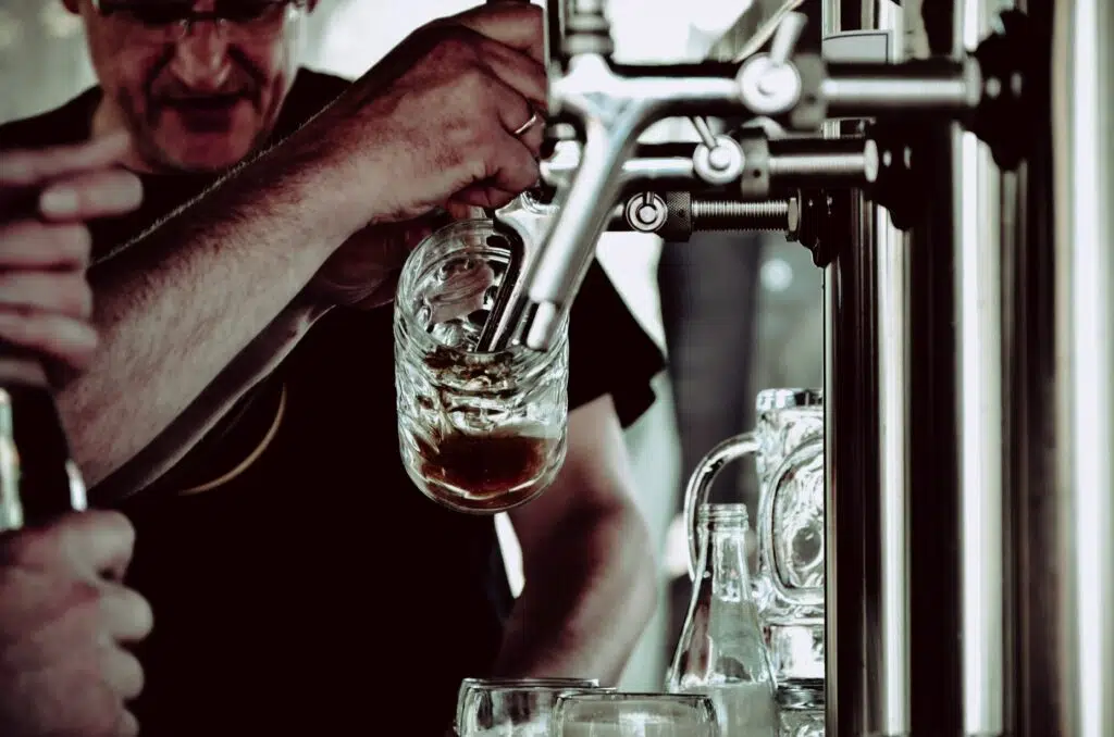 A brewer pouring a beer sample at Denver Winter Brew Fest