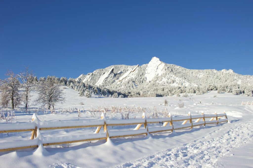 The Boulder Flatirons covered in snow on a clear winter day