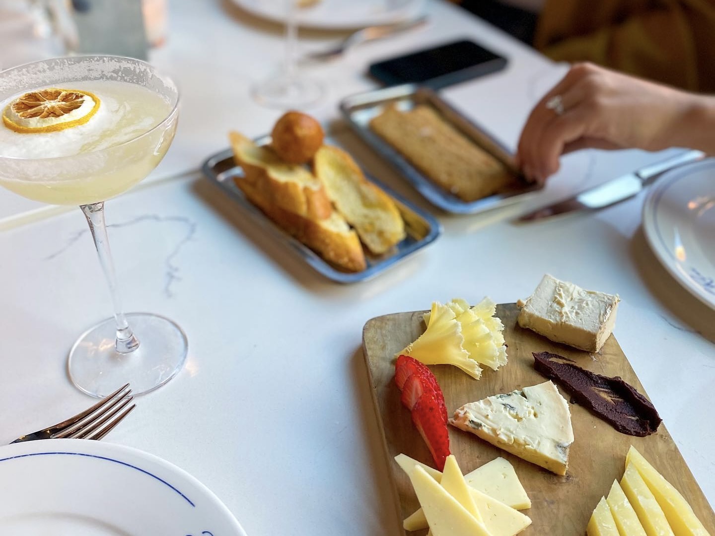 A cocktail and cheese platter from Bistro LeRoux