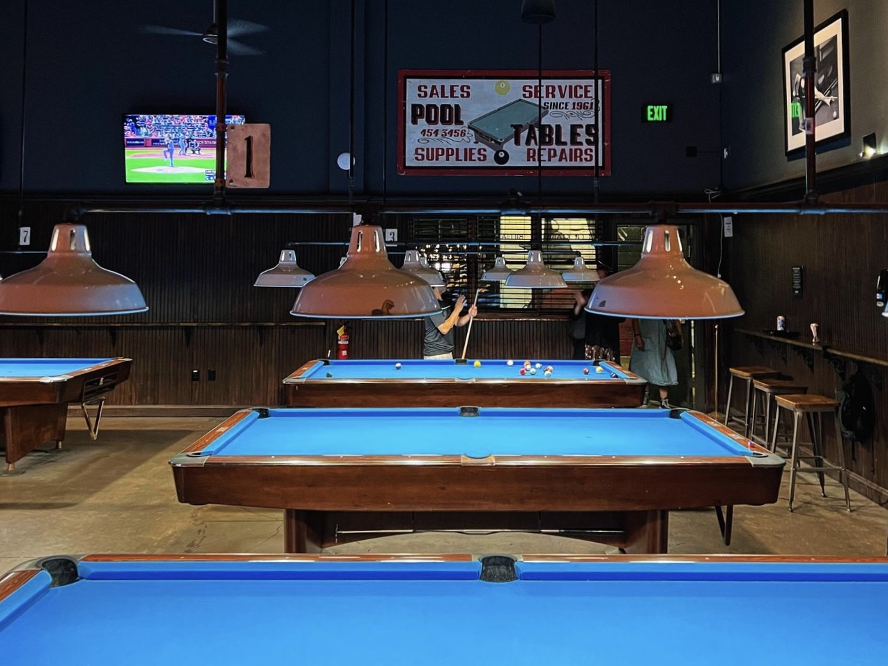 Pool tables and a flatscreen TV within Gerard's Pool Hall