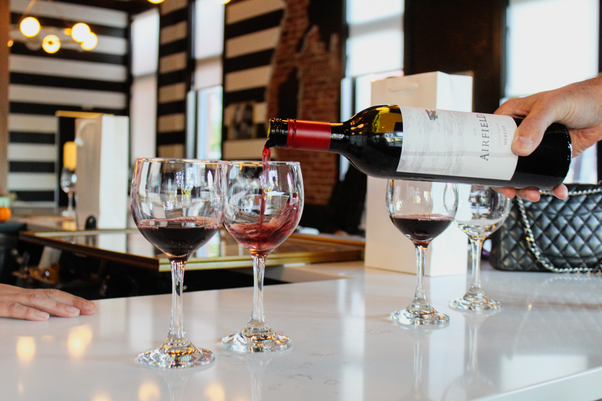 A bottle pouring wine into a glass at La Bouche