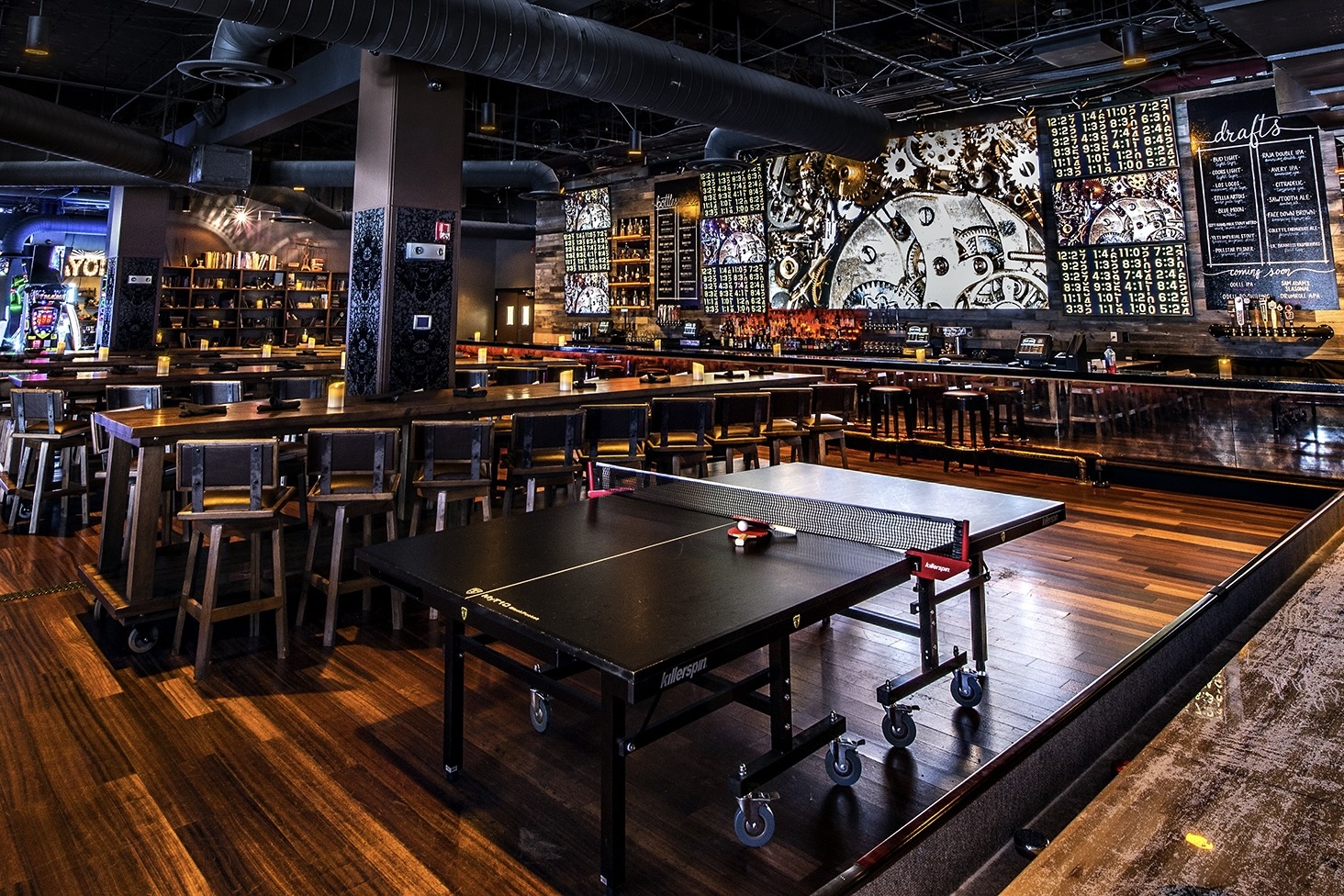 The modern interior of Lucky Strike, featuring a bar, ping pong table, and shuffleboard