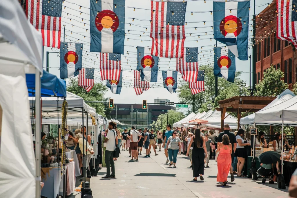 American and Colorado flags hanging above Larimer Square during its summer bazaar