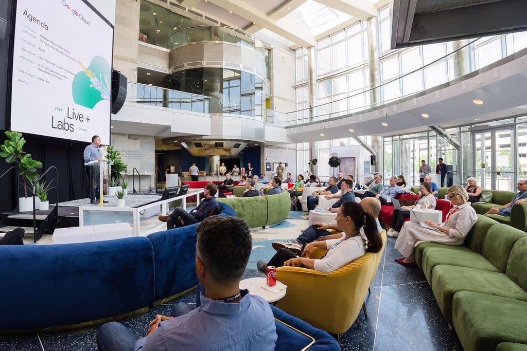 A corporate team seated on colorful sofas during a presentation at the Cable Center 