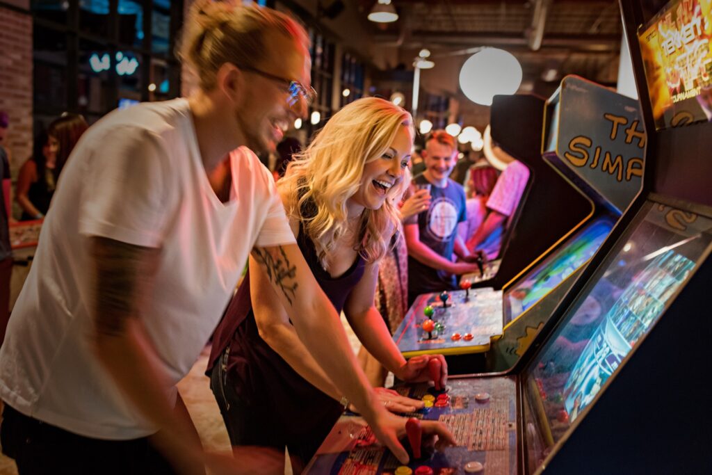 Co-workers at Punch Bowl Social playing arcade games