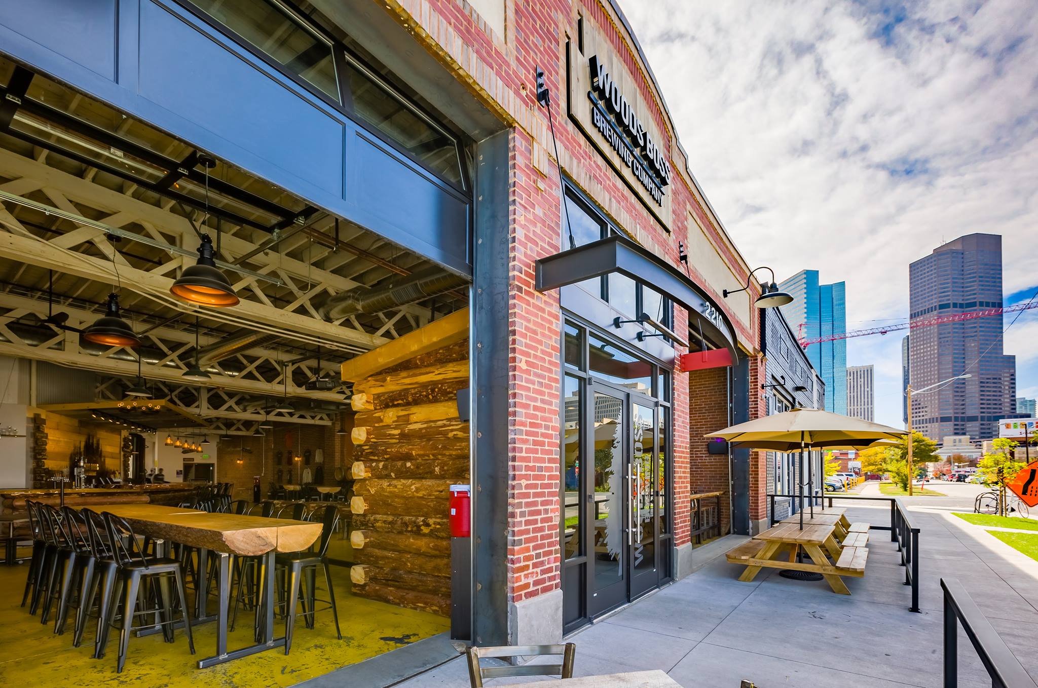 The patio of Woods Boss Brewing Company, plus a glimpse at its rustic interior through a roll-top garage door