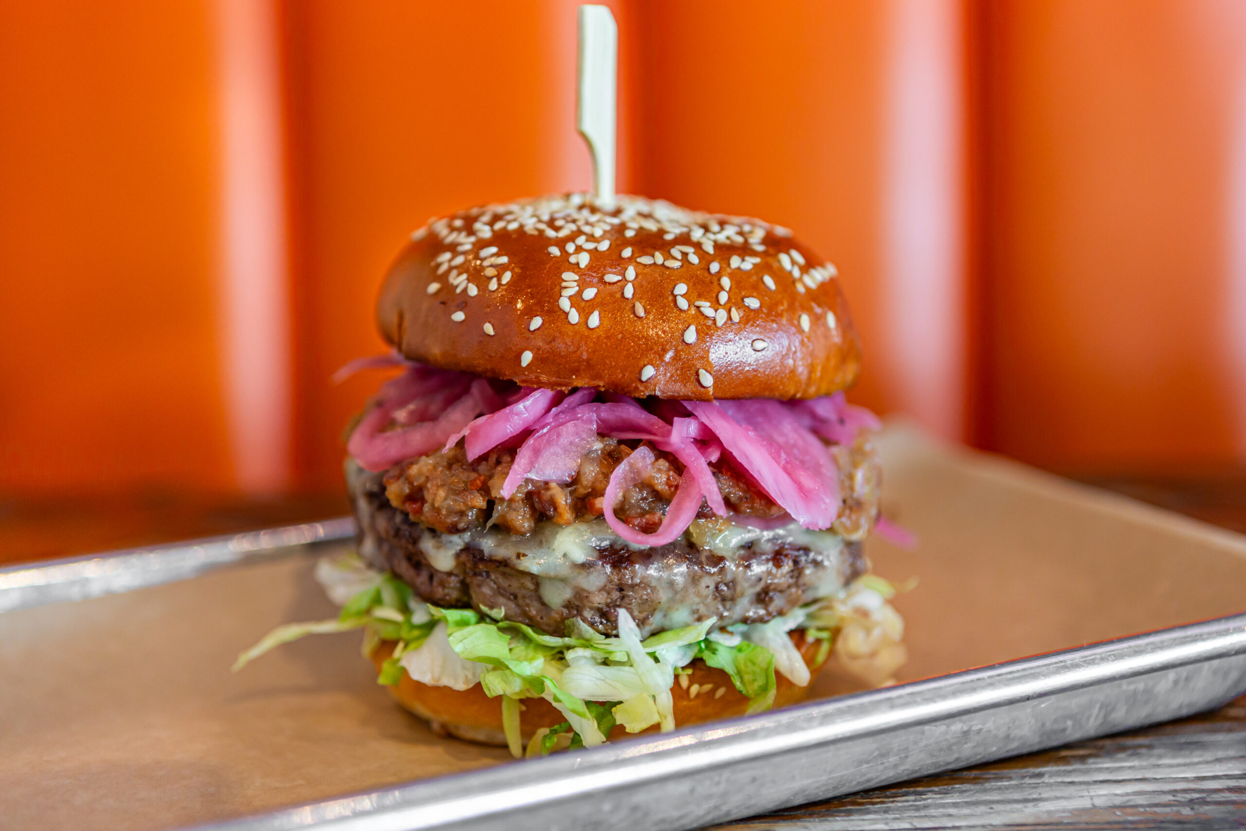 A signature burger from 5280 Burger Bar topped with pickled red onions 