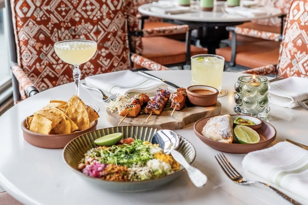 Vibrant dishes from Cimera backdropped by patterned seat cushions