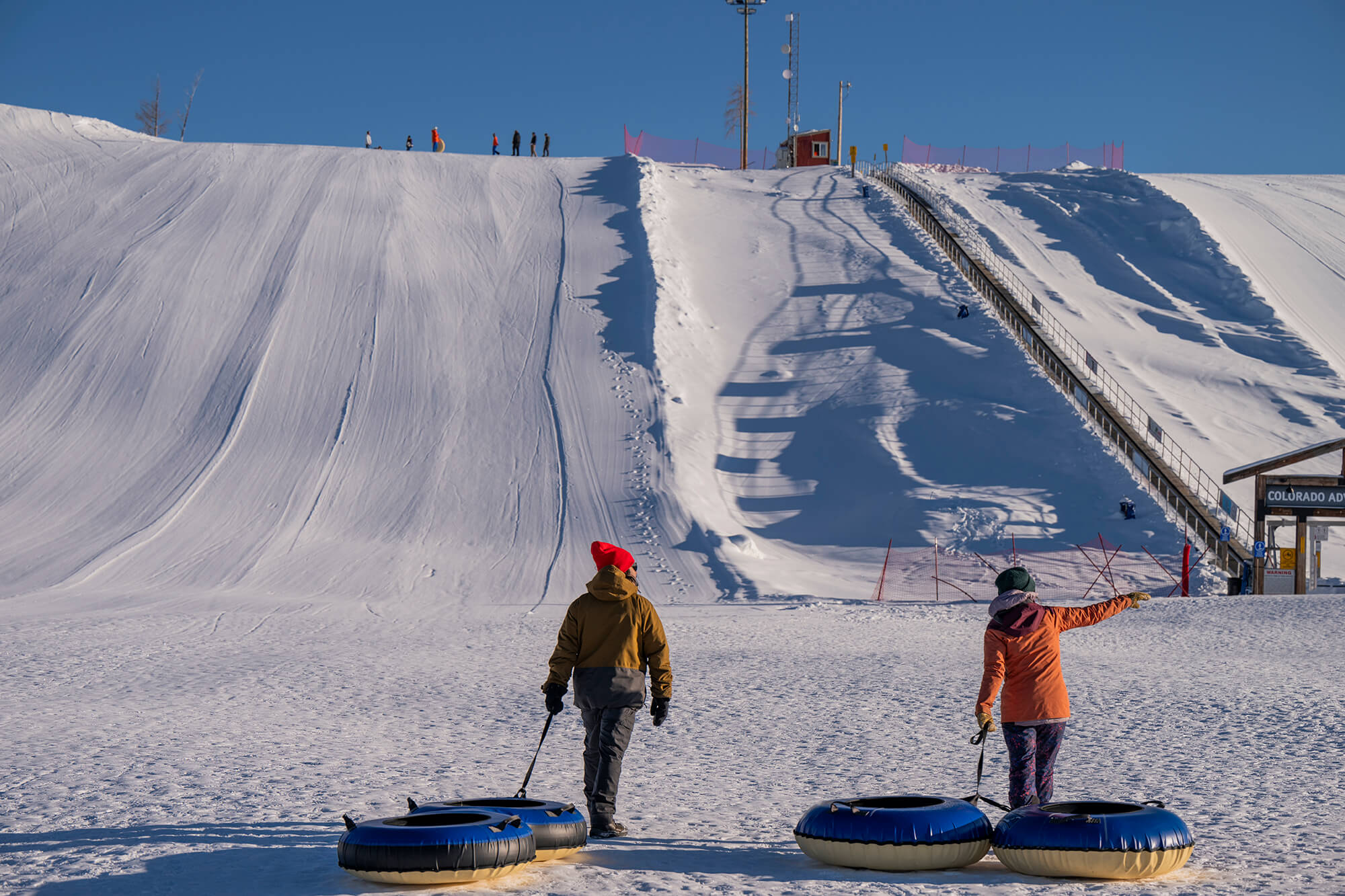 Two people at the base of the Colorado Adventure Park tubing hill