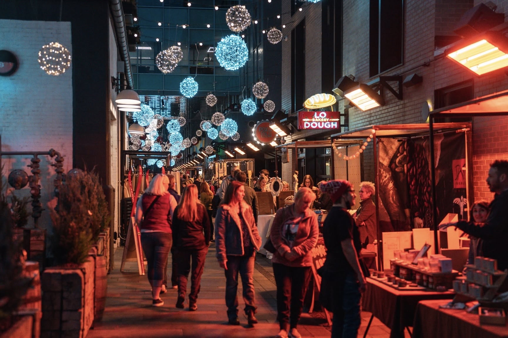 Shoppers browsing vendors within the Dairy Block alleyway