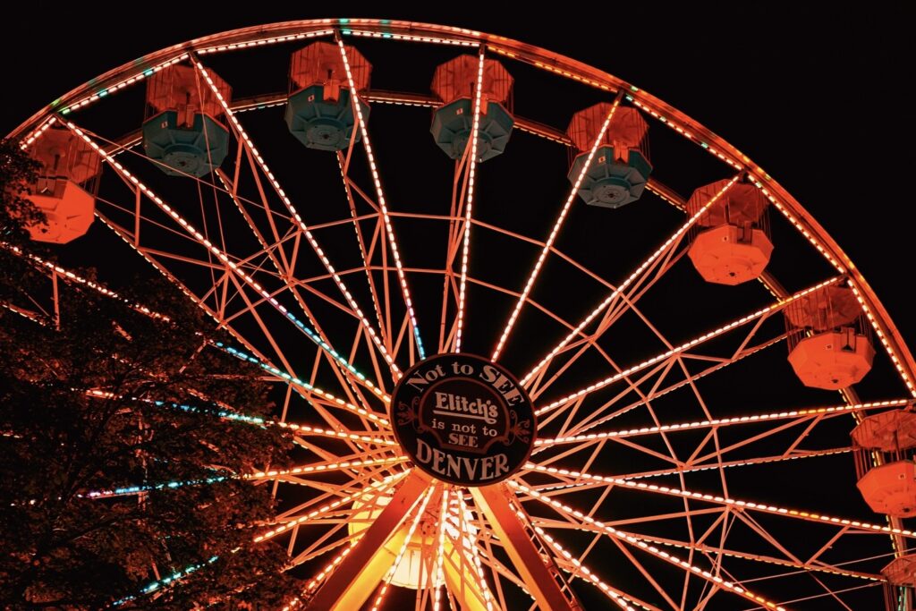 The Ferris wheel at Elitch Gardens glowing orange during Fright Fest