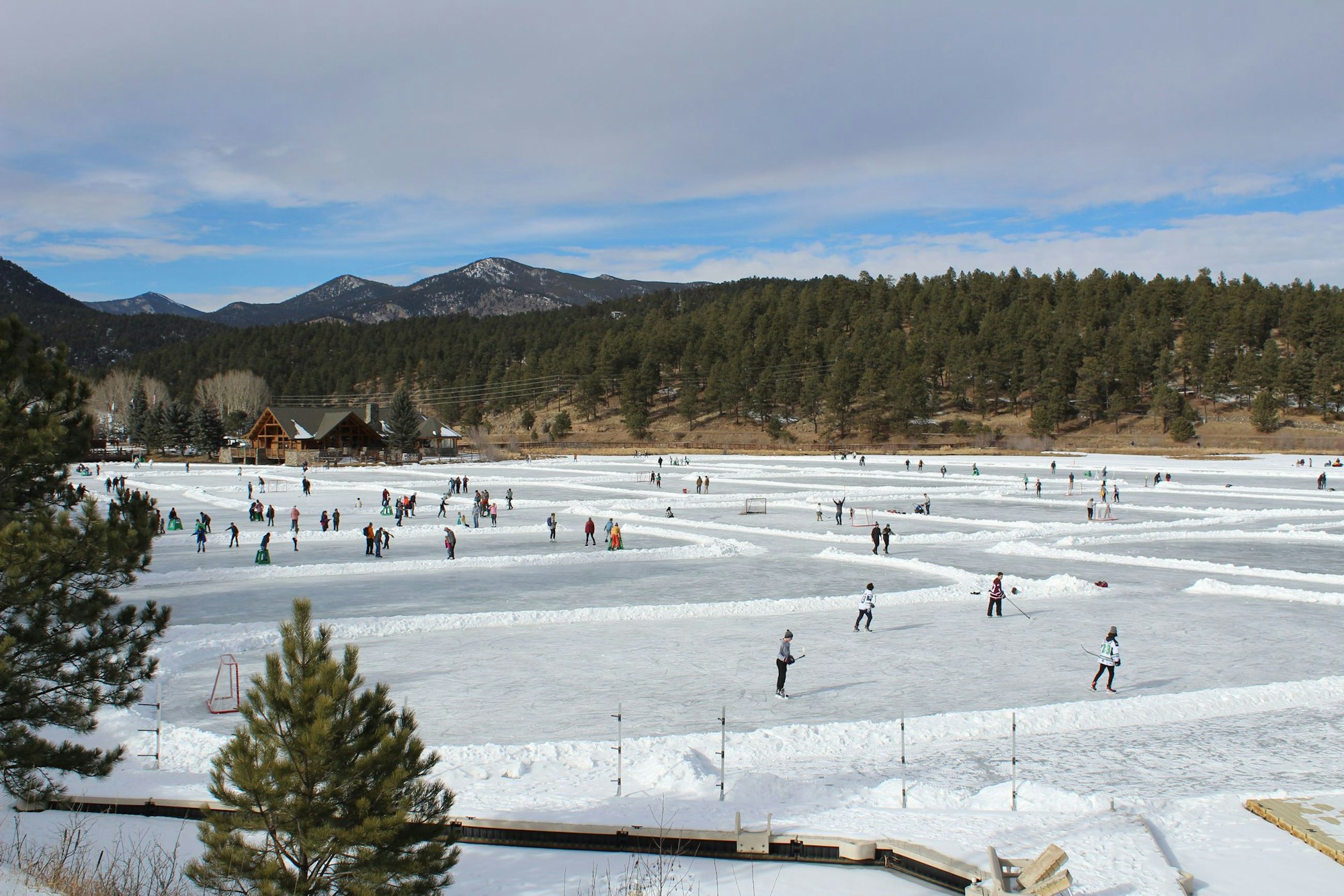 People ice skating and playing hockey on Evergreen Lake