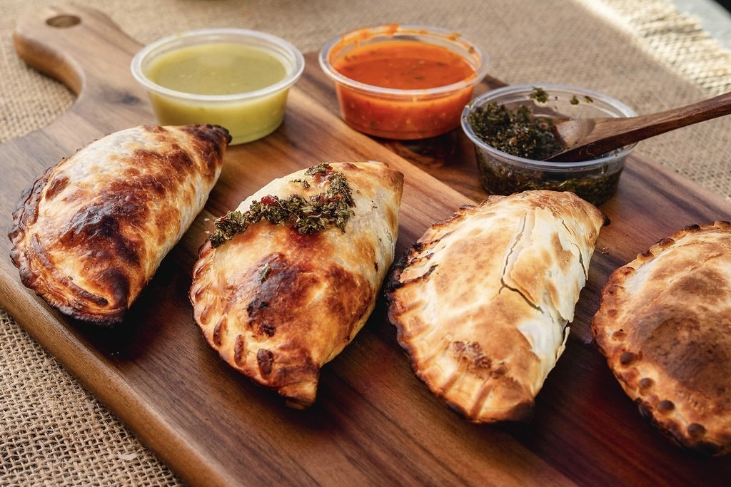 Four baked empanadas and dipping sauces from Lazo