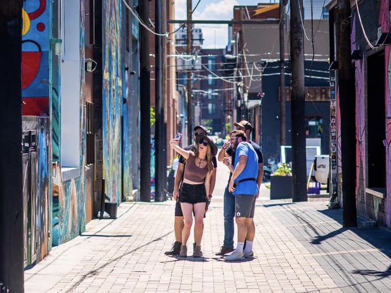 A group snapping a selfie during a Let's Roam scavenger hunt through RiNo