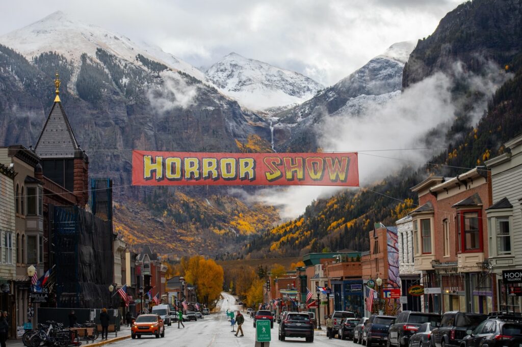 A large banner promoting the Horror Show strung between historic buildings in downtown Telluride