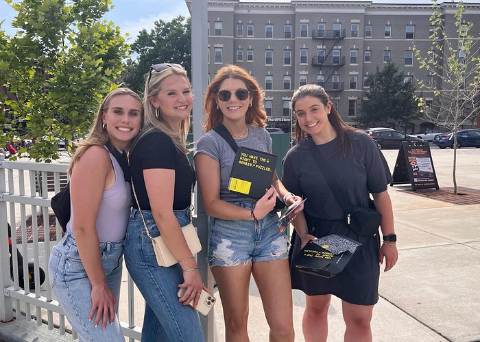 group of girls posing with a clue on outdoor escape room