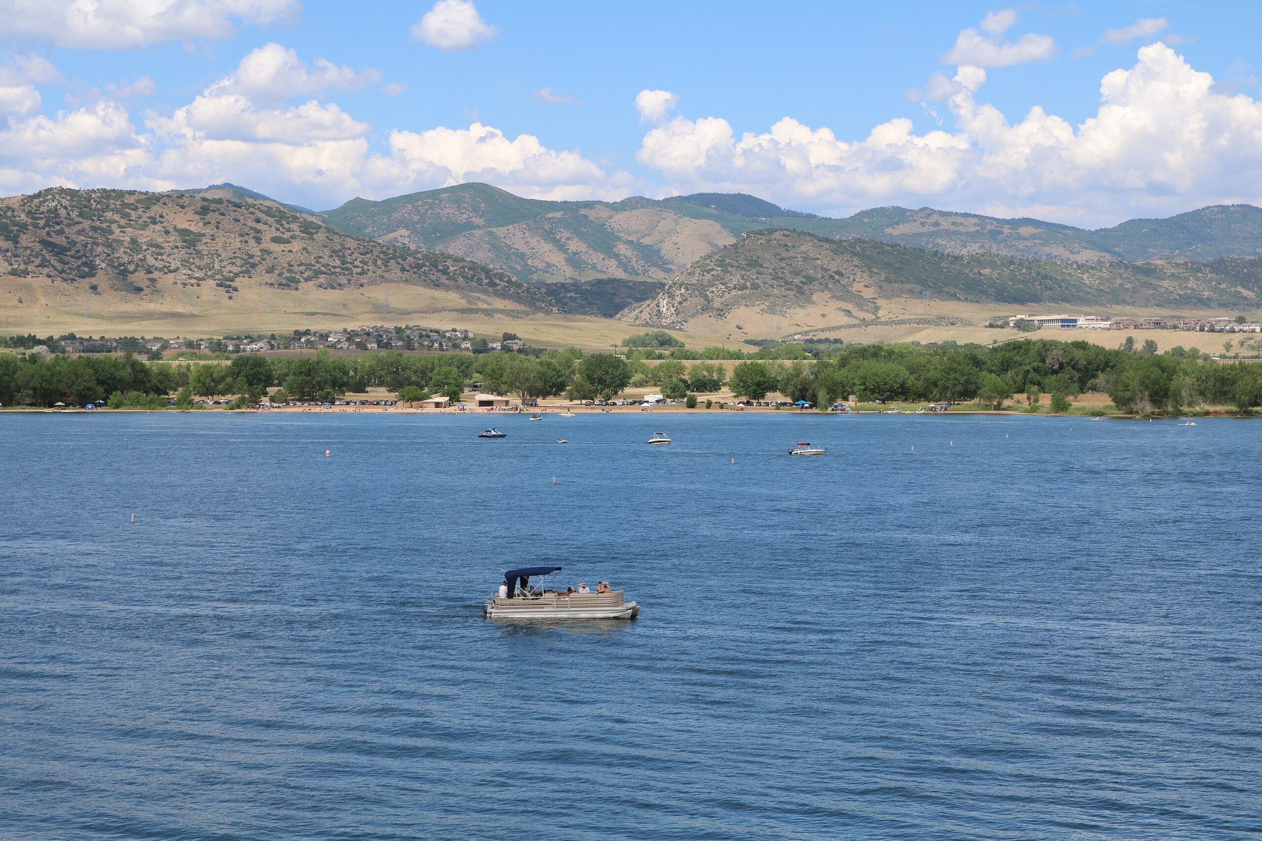 A pontoon boat on Chatfield Reservoir, with the foothills in the backdrop