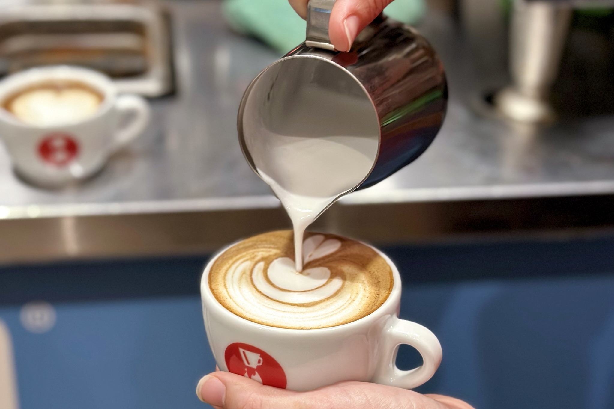 A rosetta latte art design being poured onto a drink at Novo