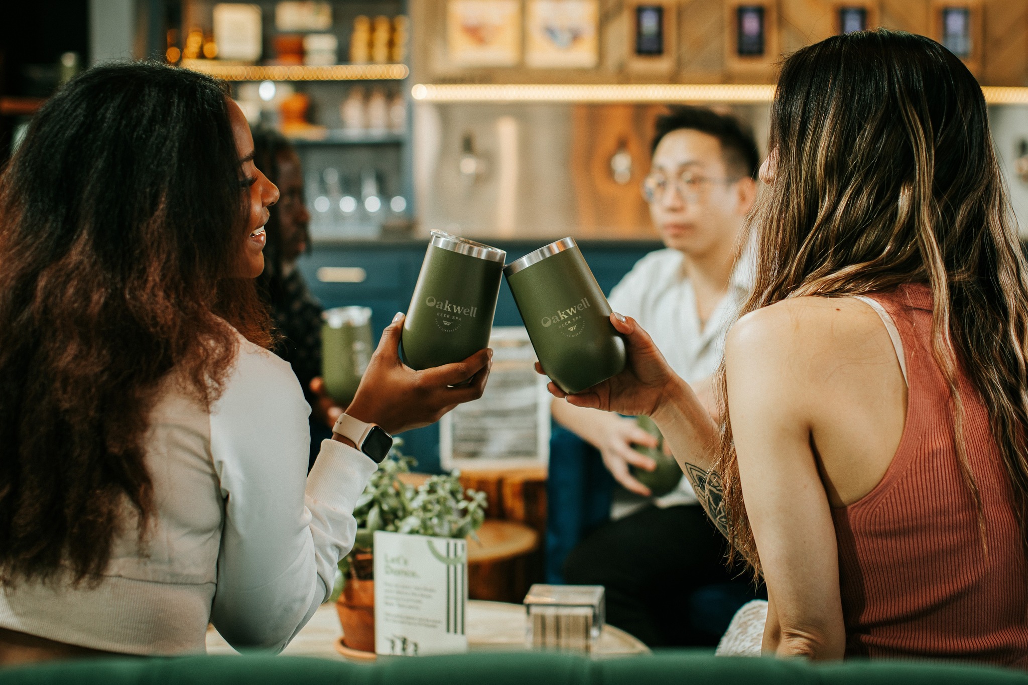 Two women toasting glasses at Oakwell Beer Spa