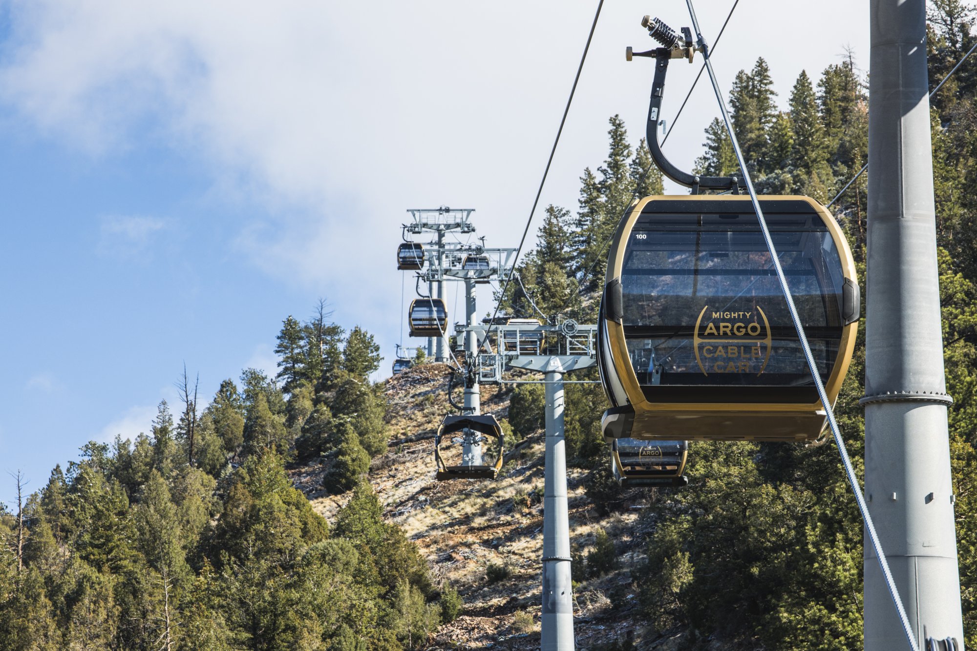 The Mighty Argo Cable Car gondola rising over a forested mountain in Idaho Springs