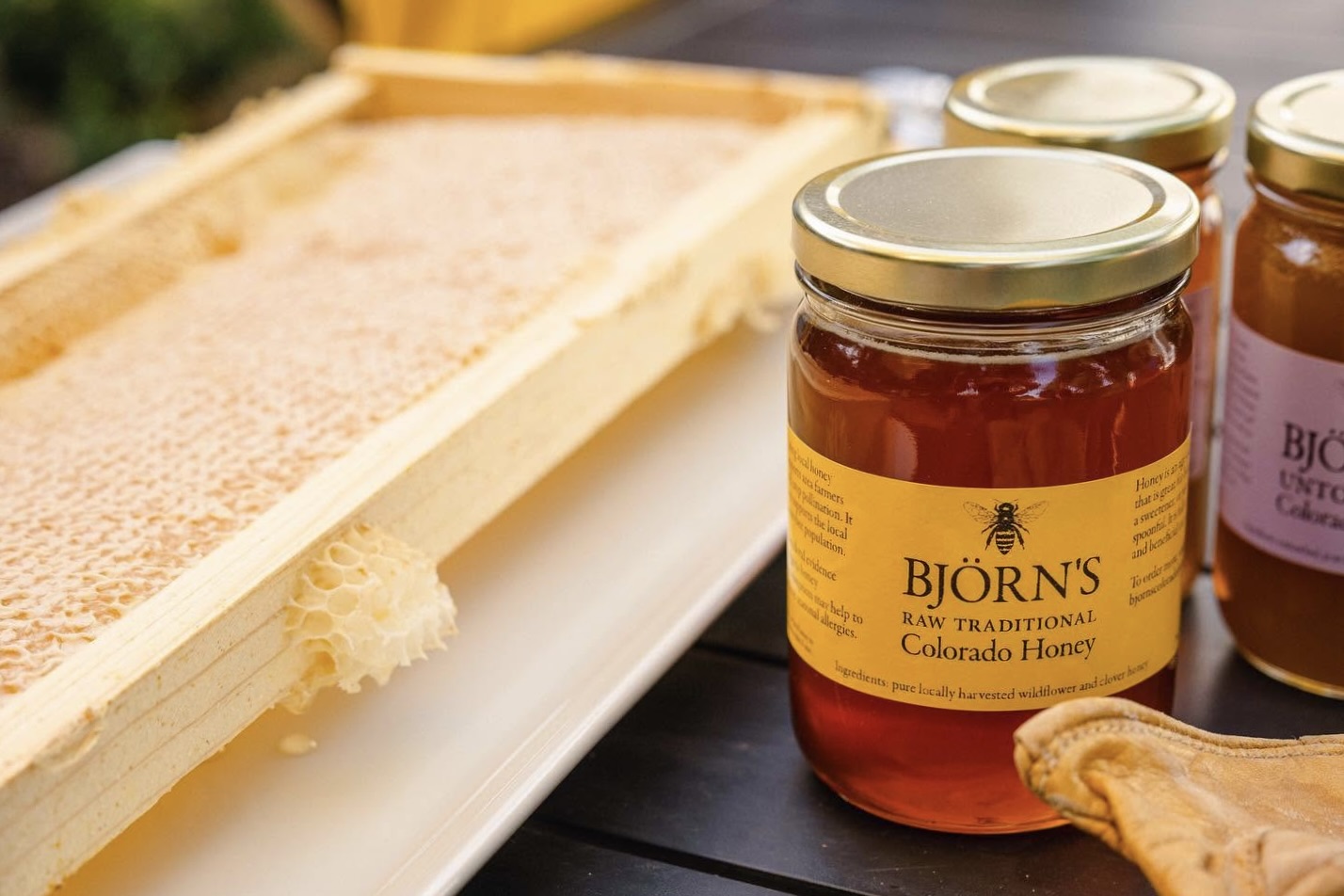Jars of Björns honey next to a full honeycomb tray