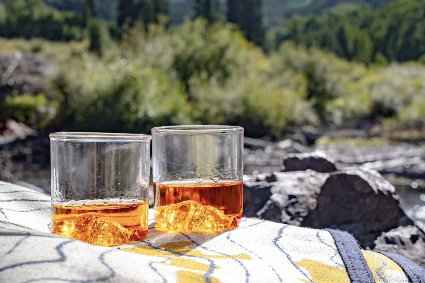 Two glass tumblers featuring the shape of the Maroon Bells at their base